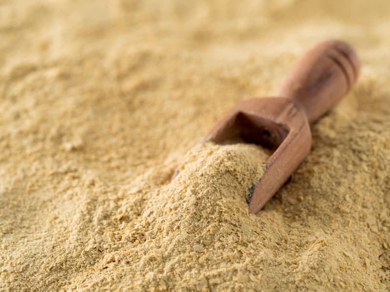 This image shows dry yeast and with a wooden scoop placed within / Hop Development Form. Ferment your beer