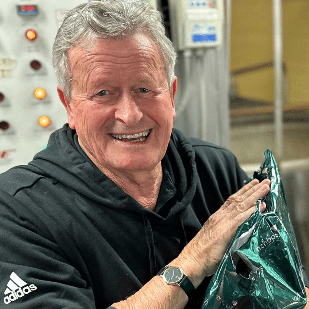 This image features Hop Breeder Dr Ron Beatson. Star guest on the Spreading Hoppiness Charles Faram podcast. In this image he is smiling while holding a bag of NZ Hop pellets.