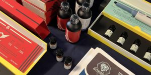 This image shows several brightly coloured bottles of Abstrax Brewing Liquids, as well as the brochures and boxes which are coloured red, blue and black